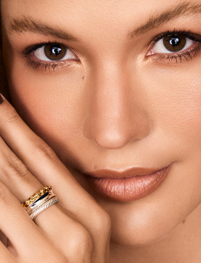 Closeup shot of human smiling female face with unusual rhinestones makeup.  Woman with earring in the form of a shiny ring in the ear on gray backgroun  Stock Photo - Alamy